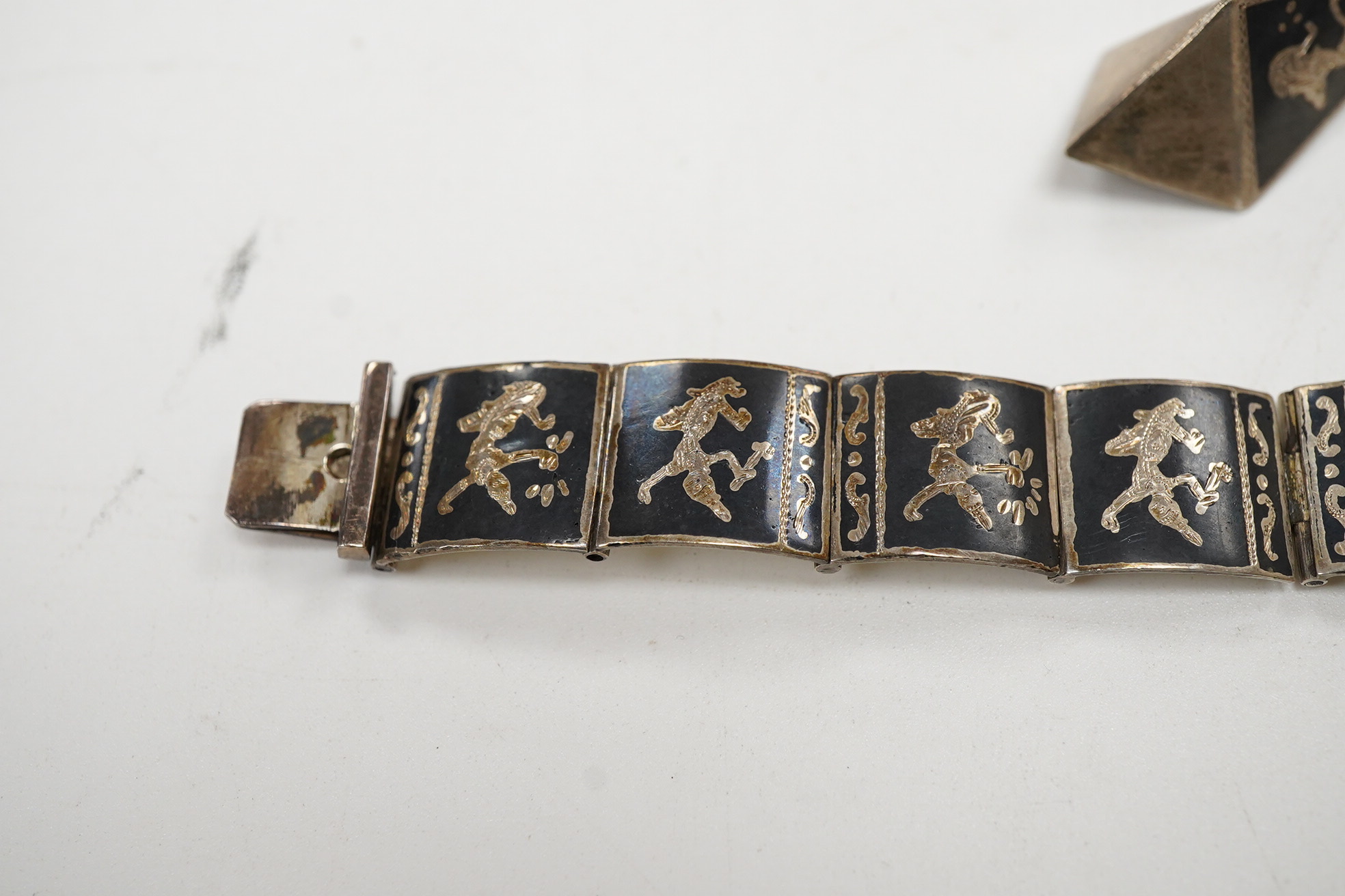 A Thai sterling and niello bracelet, 16.2cm, together with a pair of similar earrings.